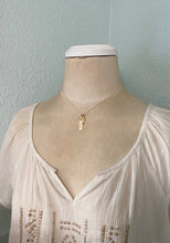 Load image into Gallery viewer, Gold tone necklace with birthstone crystal, bar with name and angel wing charm shown on mannequin