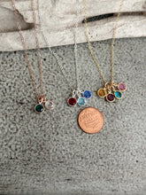 Load image into Gallery viewer, Three birthstone crystal necklaces rose gold, sterling silver and gold displayed with penny