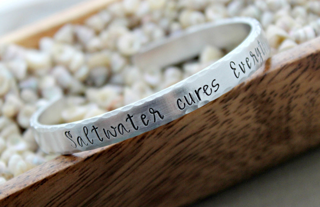 saltwater cures everything - Hand stamped bracelet - 1/4 Inch Bangle Silver tone aluminum - skinny Cuff Bracelet - gift for beach lover wave